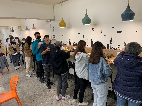 1012-微學分-原住民族文化認識-學生排隊夾取美食畫面圖片