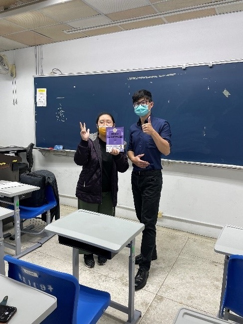 學生認真回答問題，最後獲得老師自己出版的多益講義一本圖片